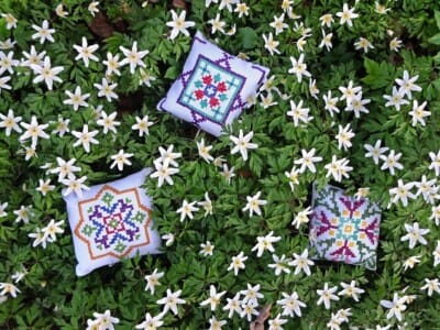 Geborduurde kussentjes tussen Bosannemonen