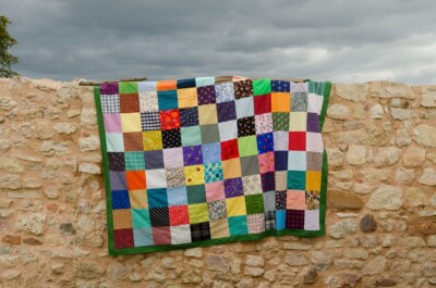 Patchwork picknickkleed over oude muur